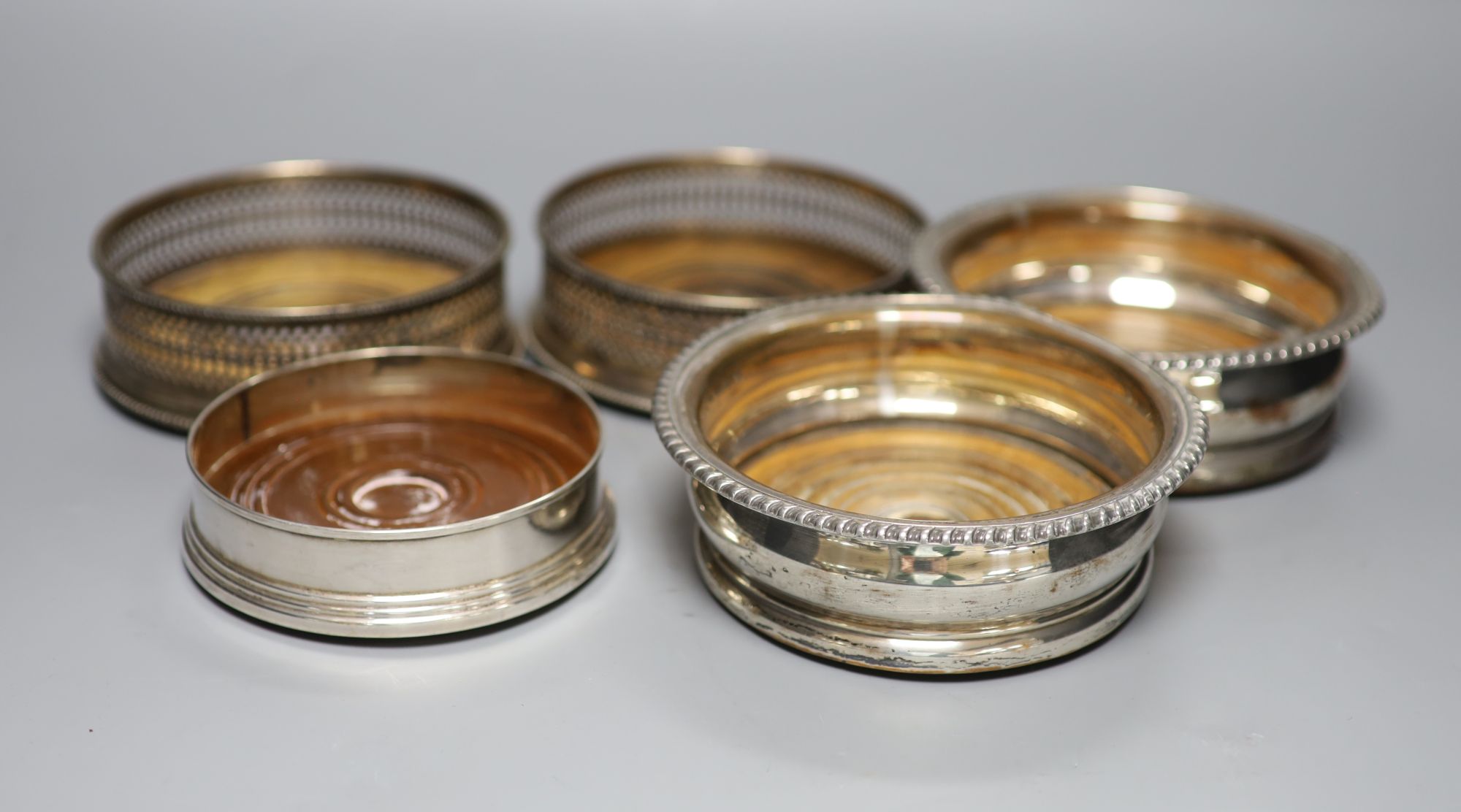 A pair of modern silver wine coasters, 13.2cm, one other modern silver coaster and a pair of plated coasters.